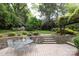 Beautiful backyard patio with stone walls, elegant outdoor dining area, and lush landscaping at 1943 S Wendover Rd, Charlotte, NC 28211