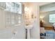Charming bathroom with white tile, pedestal sink, shuttered window, and vintage-inspired decor at 1943 S Wendover Rd, Charlotte, NC 28211