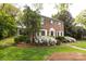 Brick two-story home with white trim, shuttered windows, and professionally landscaped yard at 1943 S Wendover Rd, Charlotte, NC 28211