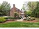 Brick home exterior featuring a well-manicured lawn, landscaped gardens, and outdoor patio at 1943 S Wendover Rd, Charlotte, NC 28211