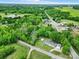 A home with a detached garage, carport and lush green lawn is seen from an aerial perspective at 1981 Line Rd, Lancaster, SC 29720
