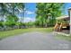 Expansive backyard featuring lush lawn, mature trees, and a spacious paved driveway leading to the home's back entrance at 1981 Line Rd, Lancaster, SC 29720