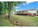 Picture of home’s backyard featuring a long wooden deck and lush lawn bordered by mature trees and with creek running thru yard at 1981 Line Rd, Lancaster, SC 29720