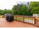 View of the back deck with wood railings and a grill, overlooking a backyard with mature trees at 1990 Country Club Dr, Lancaster, SC 29720