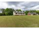 Charming yellow home with a welcoming front porch and a well-manicured lawn, set against a backdrop of trees at 1990 Country Club Dr, Lancaster, SC 29720