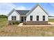 A daytime view of a charming single-story home featuring white siding and a brick foundation at 210 Goldenrod Cir, Salisbury, NC 28147
