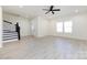 Open-concept living room with hardwood floors, white walls, natural light, and black stair railing at 240 Doster Rd, Lancaster, SC 29720