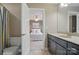 Bathroom with a view of a bedroom and with vanity with dark wood cabinets and countertop sink at 2501 Mt Isle Harbor Dr, Charlotte, NC 28214