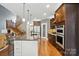 Open kitchen featuring a large island, stainless appliances, and custom cabinets at 2501 Mt Isle Harbor Dr, Charlotte, NC 28214