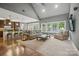 Spacious living room with hardwood floors, large windows, and cozy seating with an open kitchen at 2501 Mt Isle Harbor Dr, Charlotte, NC 28214
