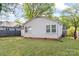 White home featuring a spacious, grassy backyard with mature trees and window views at 288 Fink Nw Ave, Concord, NC 28025