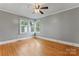 This bedroom features hardwood floors, neutral paint, ceiling fan, and large windows at 288 Fink Nw Ave, Concord, NC 28025