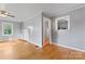 Sunlit room featuring hardwood floors, neutral paint, and a view into the kitchen at 288 Fink Nw Ave, Concord, NC 28025