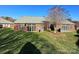Large backyard with green grass, a brick home, an awning, and a pretty bare tree at 4223 Willow View Ct, Matthews, NC 28105