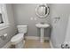 A half bath featuring a pedestal sink, toilet, and window at 510 S Carolina Ave, Spencer, NC 28159