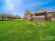 View of the back of the house with a screened-in porch and large, green backyard at 514 Clover Leaf Rd, Marshville, NC 28103