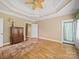 Cozy bedroom with hardwood floors, tray ceiling with fan, and a doorway to another room at 514 Clover Leaf Rd, Marshville, NC 28103