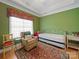Cozy bedroom featuring a trundle bed, recliner, and green accent wall at 514 Clover Leaf Rd, Marshville, NC 28103