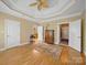 Bright bedroom with hardwood floors, tray ceilings, and multiple entryways creating a welcoming atmosphere at 514 Clover Leaf Rd, Marshville, NC 28103