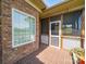 Close-up of a screened-in porch featuring brick flooring and views of the outdoor scenery at 514 Clover Leaf Rd, Marshville, NC 28103
