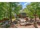 Backyard with screened porch, fire pit, water feature, lush landscaping, hardscaping, and nearby trees at 5283 Fieldstone Dr, Concord, NC 28025