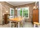 Dining area featuring brick accent walls, a wooden table, and lots of sunlight at 5283 Fieldstone Dr, Concord, NC 28025