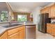 Kitchen area with stainless steel refrigerator and dishwasher with brick wall accent at 5283 Fieldstone Dr, Concord, NC 28025