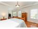 Bright main bedroom features tray ceilings, hardwood floors, and abundant natural light from large windows at 5283 Fieldstone Dr, Concord, NC 28025