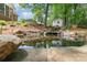 Backyard water feature with gentle waterfall, goldfish, lush landscaping, and storage shed at 5283 Fieldstone Dr, Concord, NC 28025