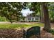 Charming home surrounded by lush greenery, featuring a serene front yard with a bench and mature trees offering shade at 539 Marsh Rd, Charlotte, NC 28209