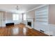Inviting living room with a fireplace, built-in shelving, and gleaming hardwood floors at 539 Marsh Rd, Charlotte, NC 28209