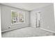 Bright bedroom with gray carpet and walls, featuring two windows providing natural light at 6135 Raisin Tree Ln, Charlotte, NC 28215