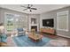 Staged living room with cozy fireplace, plush seating, modern decor, and natural light at 6135 Raisin Tree Ln, Charlotte, NC 28215