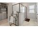Bright bathroom featuring a glass-enclosed shower, marble floors, and a towel rack next to a walk-in closet at 6145 Holland St, Fort Mill, SC 29707