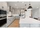 Modern kitchen with white cabinets, stainless steel appliances, pendant lighting and a large center island at 6145 Holland St, Fort Mill, SC 29707