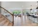 Open-concept living area featuring large windows, staircase and island seating at 6145 Holland St, Fort Mill, SC 29707