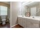 Well-lit bathroom with double sinks, a large mirror, and wooden floor at 6622 Cedar Cliff Dr, Charlotte, NC 28216