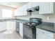 Well-lit kitchen featuring white cabinets, gray countertops, and modern black appliances at 6622 Cedar Cliff Dr, Charlotte, NC 28216