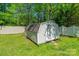 Backyard storage shed with double doors surrounded by a well-maintained lawn at 6622 Cedar Cliff Dr, Charlotte, NC 28216