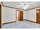 Spacious bedroom featuring soft carpet and white walls with wood trim and ceiling fan at 704 Colby Cir, Salisbury, NC 28147