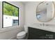 Modern bathroom featuring a stylish vanity, round mirror, and contemporary fixtures at 721 Charles Ave, Charlotte, NC 28205