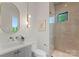 Modern bathroom with gray vanity, oval mirror, and glass-enclosed shower at 721 Charles Ave, Charlotte, NC 28205
