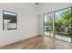 Light bedroom features hardwood floors and expansive windows with neighborhood views at 721 Charles Ave, Charlotte, NC 28205