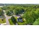 This aerial view shows the home situated on a verdant lot with mature trees, providing privacy and charm at 7239 Oxford Hunt Dr, Stanley, NC 28164