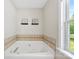 Bathroom featuring a large soaking tub with tile surround at 7239 Oxford Hunt Dr, Stanley, NC 28164