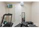 Basement gym area with treadmill, weight bench, and wall-mounted television at 7239 Oxford Hunt Dr, Stanley, NC 28164
