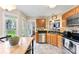 Spacious kitchen with wood cabinetry, stainless steel appliances, granite countertops, and access to the backyard at 7239 Oxford Hunt Dr, Stanley, NC 28164