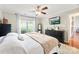 Main bedroom features a ceiling fan, hardwood floors, and a large window overlooking the backyard at 7239 Oxford Hunt Dr, Stanley, NC 28164