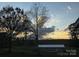 Scenic view of the backyard with trees and a charming outbuilding at sunset at 7527 Old Shelby Rd, Vale, NC 28168