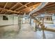 A basement featuring exposed ceiling beams, concrete floor, and freshly painted white walls at 7527 Old Shelby Rd, Vale, NC 28168